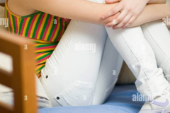 portrait-of-teenage-girl-sitting-on-a-sofa-F9J7FM